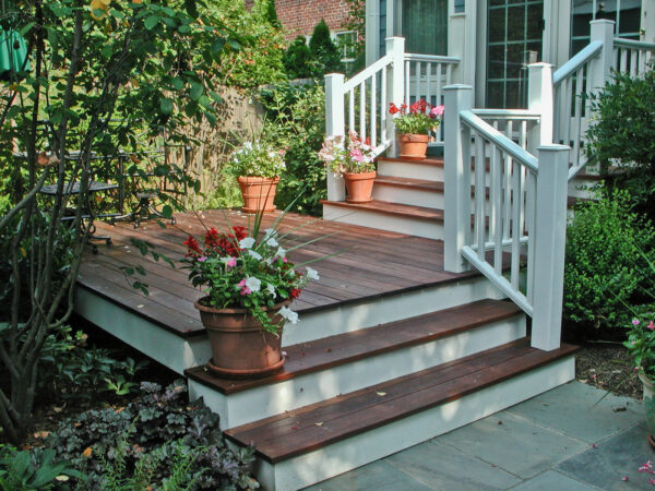 use ipe hardwood for a small backyard deck with colorful flowers and a composite railing