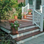 use ipe hardwood for a small backyard deck with colorful flowers and a composite railing