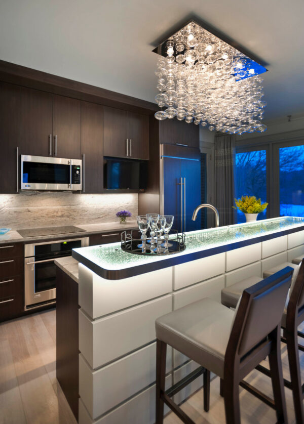 a granite backsplash and a glass chandelier can transform your galley kitchen with an island into an elegant space