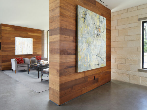 pair limestone walls and a false wood wall with a dramatic artwork for a contemporary living room