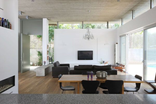 this beautiful open concept living room uses a false wall and plaster fireplace for the quintessential modern atmosphere