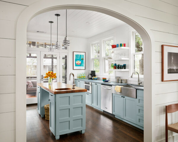 this galley kitchen with an island combines white heron oc-57 by benjamin moore and white oak wood flooring for a farmhouse vibe