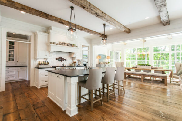 use exposed wooden beams in a galley kitchen with an island to add dramatic architectural intrigue